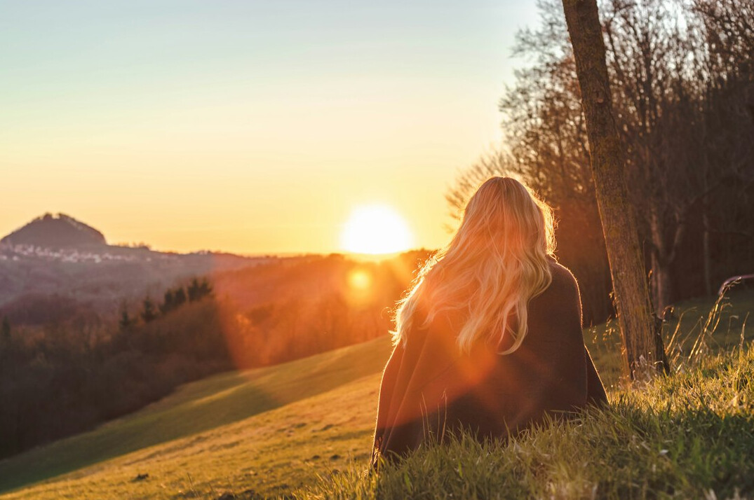 Woman meditating outdoors at sunrise